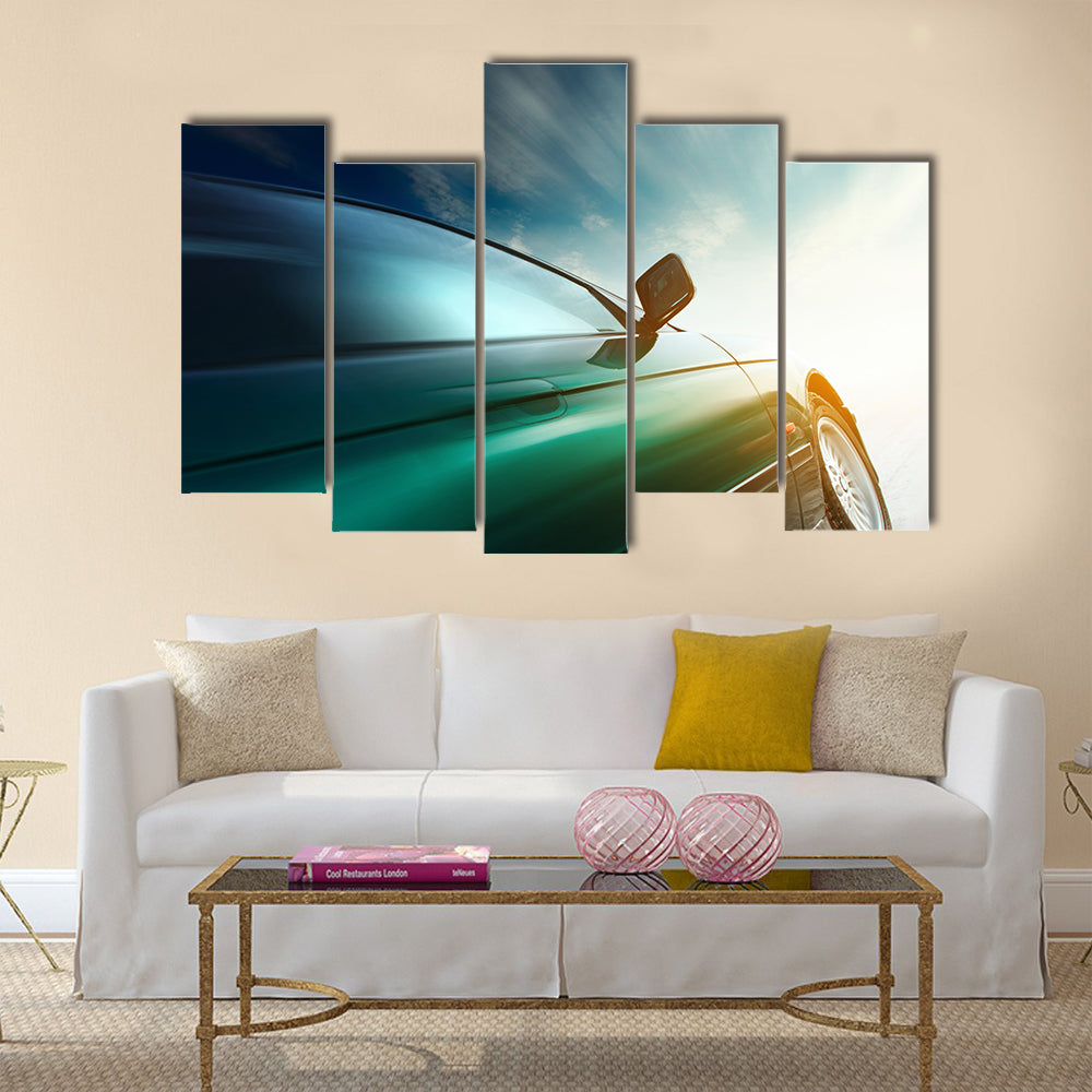 Blurred car on road and sky with clouds Multi panel canvas wall art