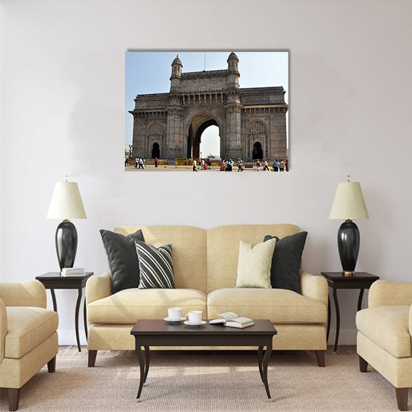 A group of people walk under the Gateway of India Multi Panel Canvas Wall Art