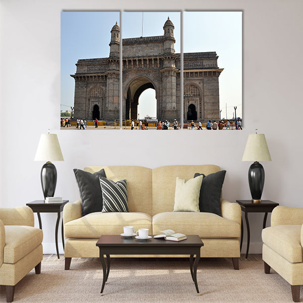 A group of people walk under the Gateway of India Multi Panel Canvas Wall Art