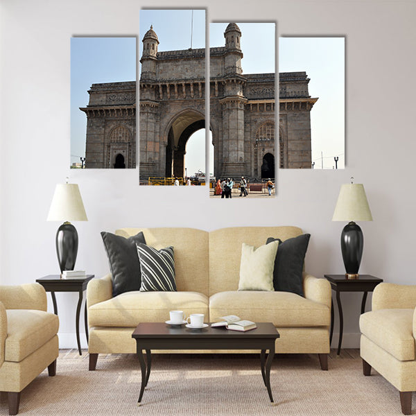 A group of people walk under the Gateway of India Multi Panel Canvas Wall Art