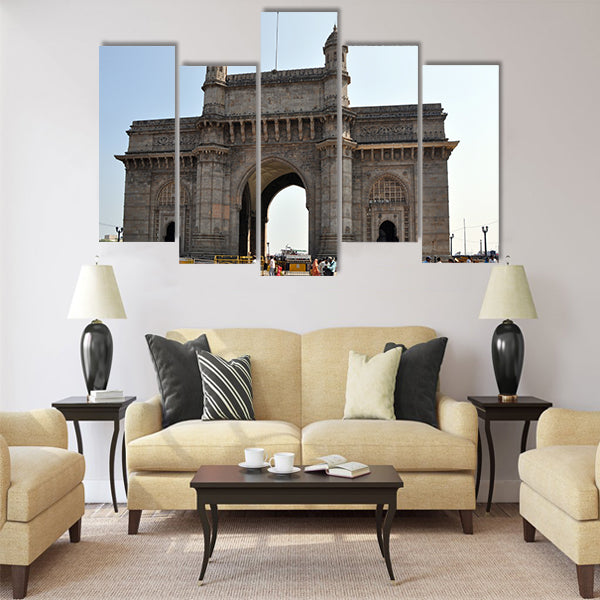 A group of people walk under the Gateway of India Multi Panel Canvas Wall Art