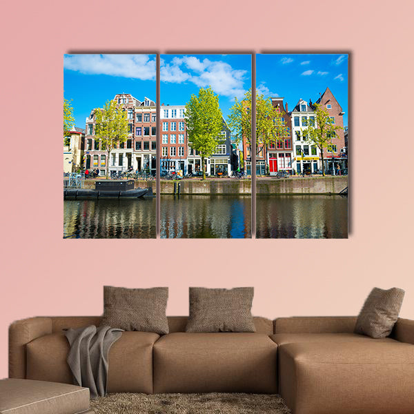 View of the ancient buildings, streets, people, embankments of Amsterdam multi panel canvas wall art