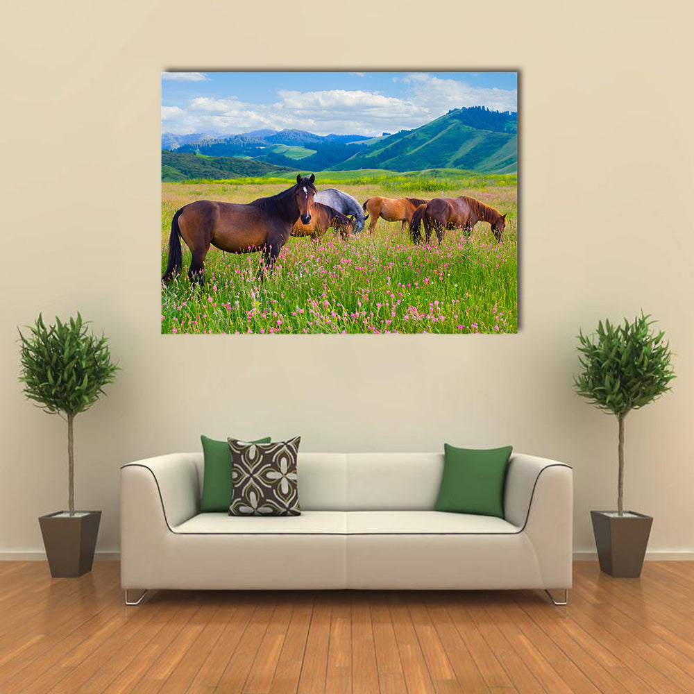 The herd of horses is grazed on a summer green meadow multi panel canvas wall art