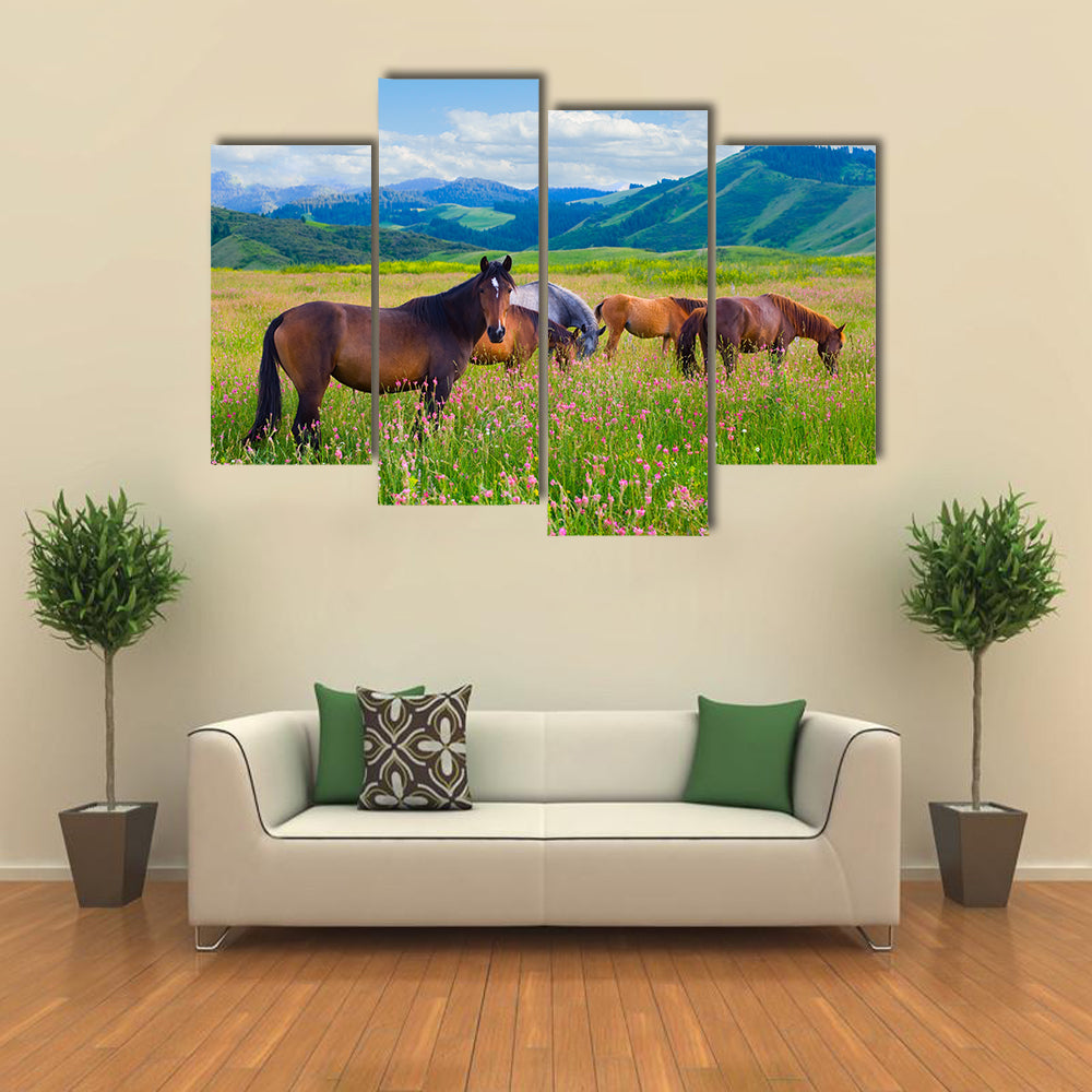 The herd of horses is grazed on a summer green meadow multi panel canvas wall art