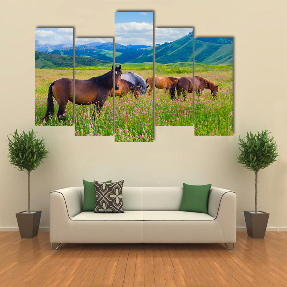 The herd of horses is grazed on a summer green meadow multi panel canvas wall art