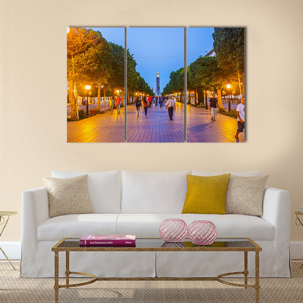 The evening walk along the illuminated Avenue with a view on the modern Clock Tower Multi panel canvas wall art