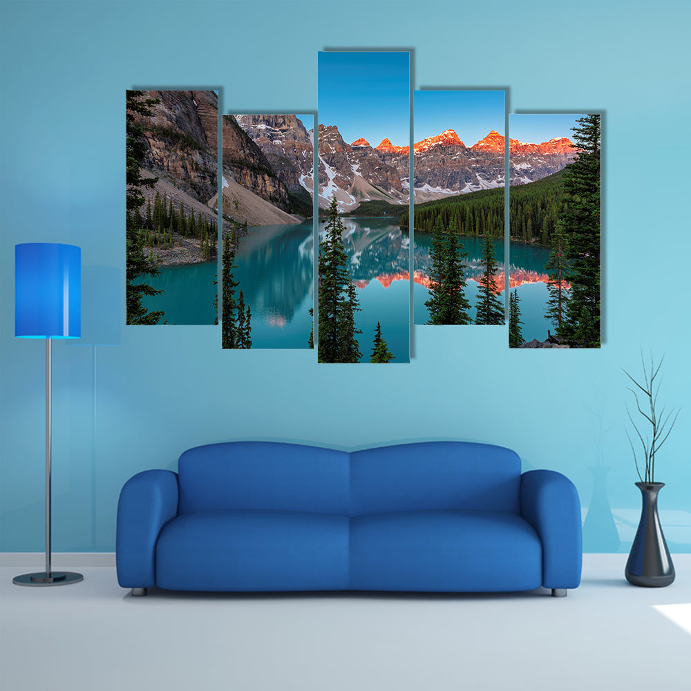A beautiful sunrise at Moraine Lake with snow covered peaks multi panel canvas wall art