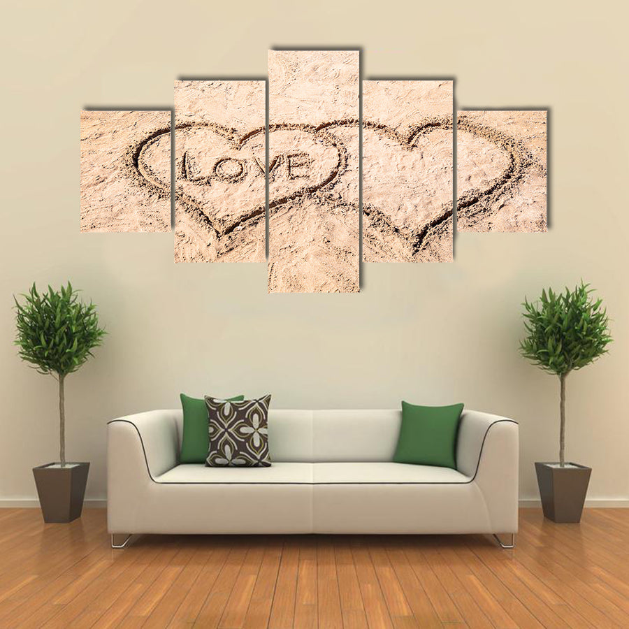 Word LOVE and hearts drawn on sand near water multi panel canvas wall art