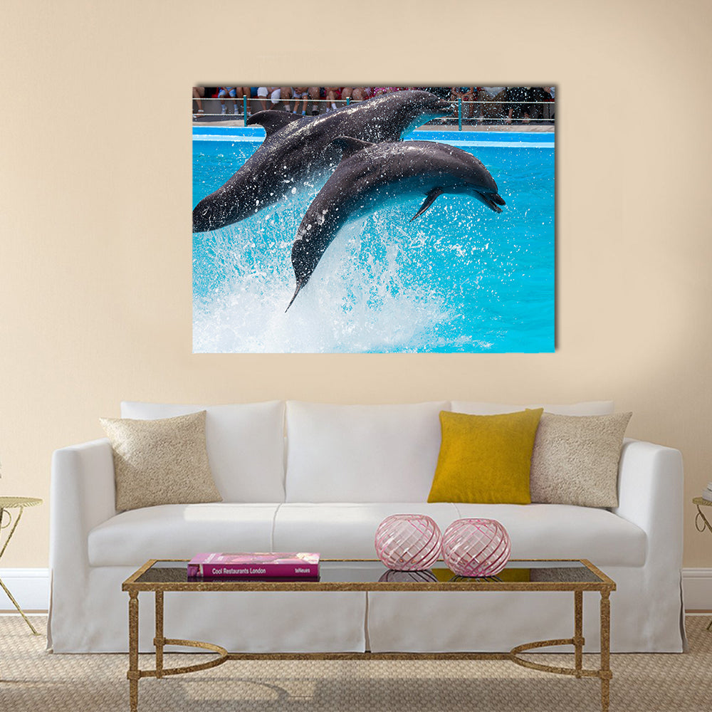 Two dolphins jump out of the pool water during the performance multi panel canvas wall art