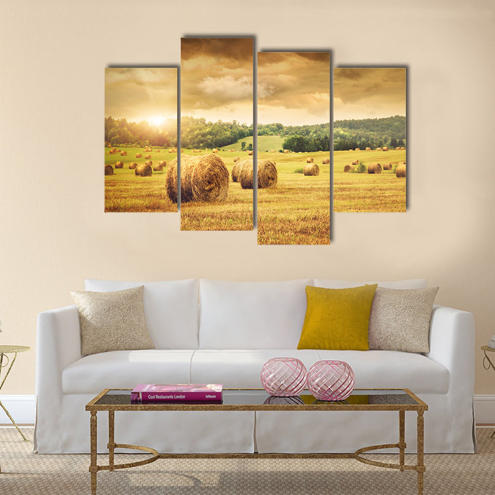 Field of freshly cut bales of hay with beautiful sunset Multi panel canvas wall art