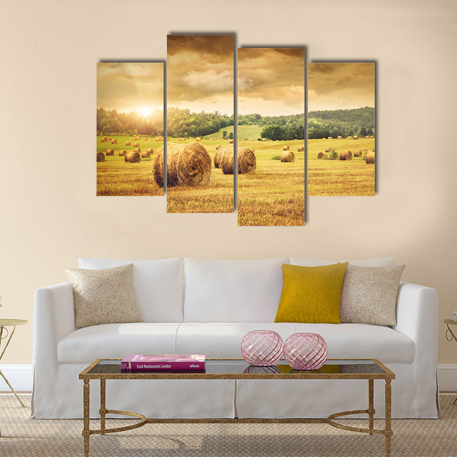 Field of freshly cut bales of hay with beautiful sunset Multi panel canvas wall art