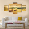 Field of freshly cut bales of hay with beautiful sunset Multi panel canvas wall art