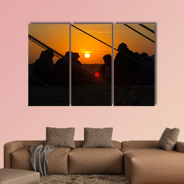 Arab men around a fire place in the desert at sunrise multi panel canvas wall art