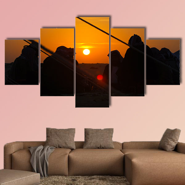 Arab men around a fire place in the desert at sunrise multi panel canvas wall art