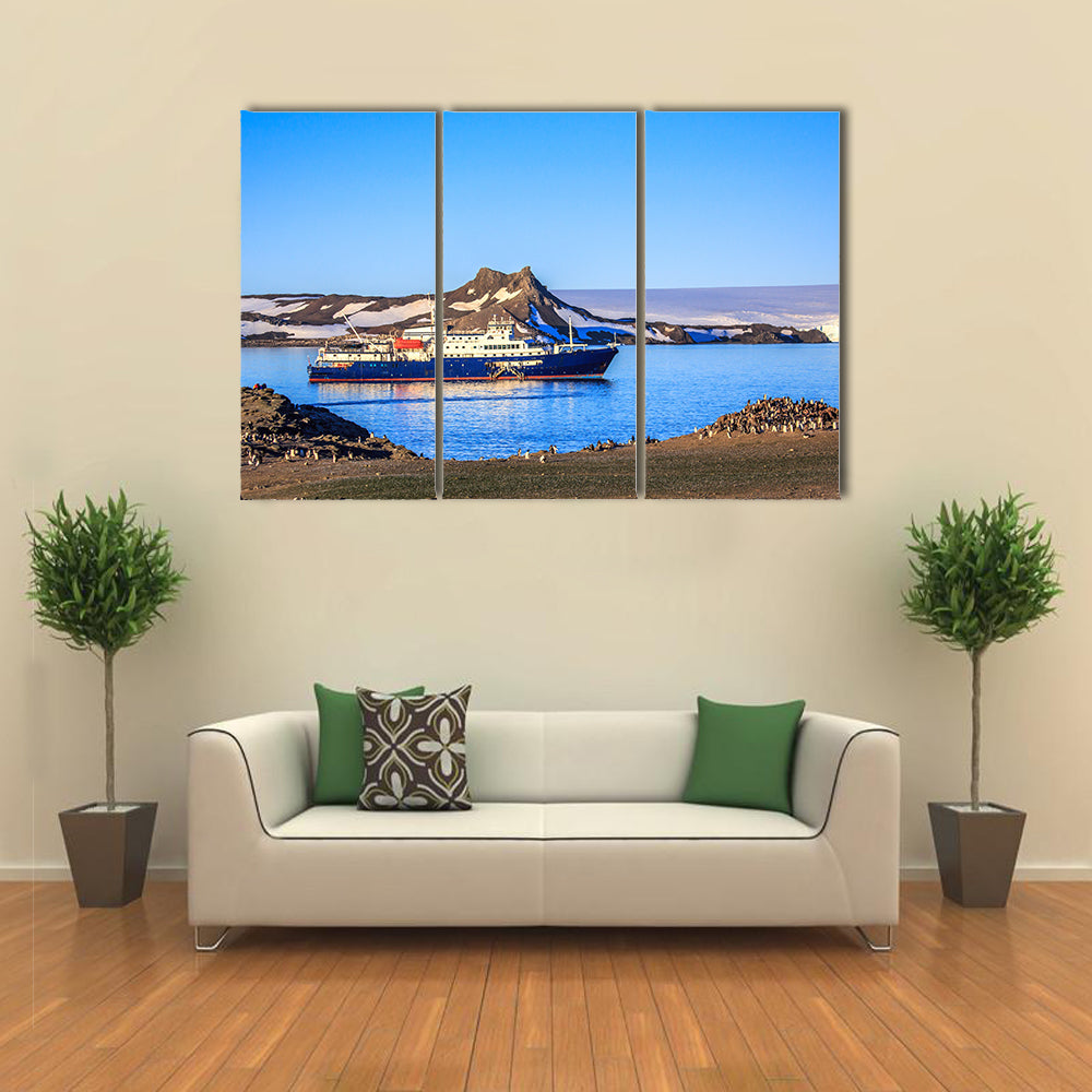 Blue antarctic cruise ship in the lagoon and penguins colony on the island Multi panel canvas wall art