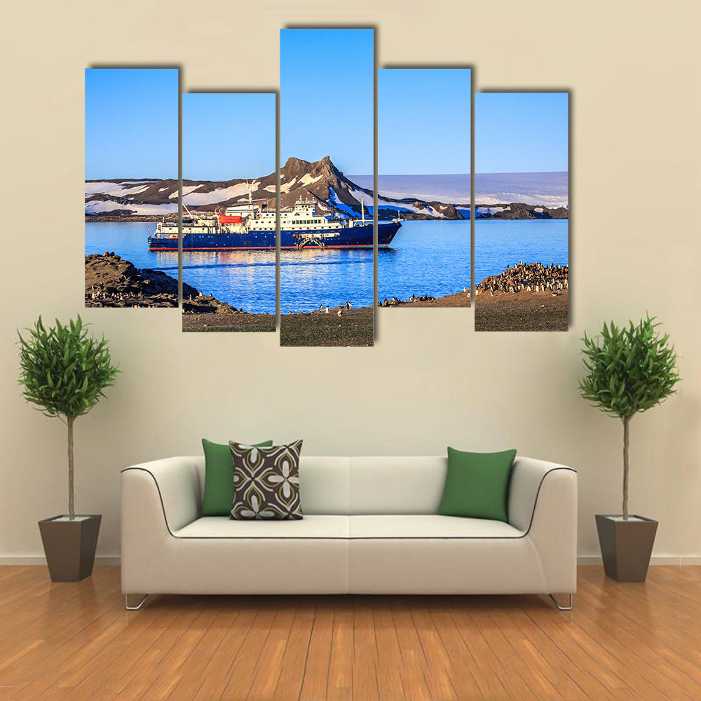 Blue antarctic cruise ship in the lagoon and penguins colony on the island Multi panel canvas wall art