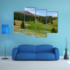 Grassy meadow at the foot of the mountain, beautiful landscape with spruce forest on hillside multi panel canvas wall art