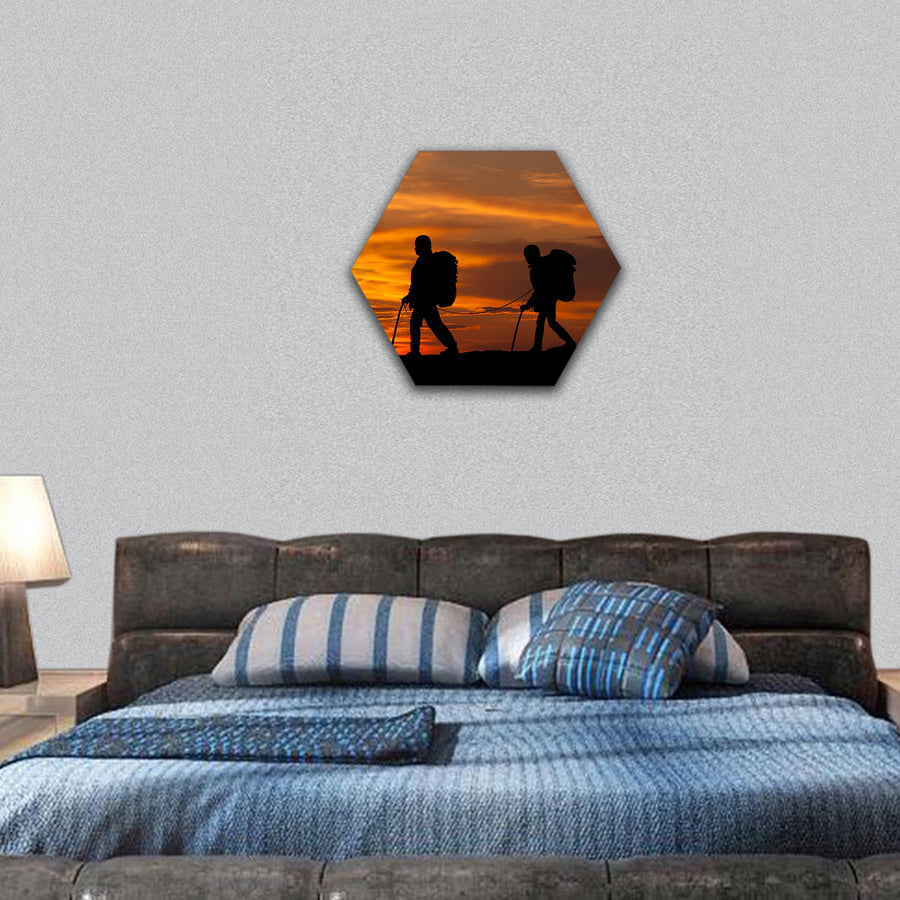 silhouette of two walking rock climbers on sunset sky hexagonal canvas wall art