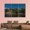 Amazing lake surrounded by greenery and old brick building multi panel canvas wall art