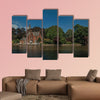 Amazing lake surrounded by greenery and old brick building multi panel canvas wall art