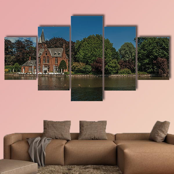 Amazing lake surrounded by greenery and old brick building multi panel canvas wall art