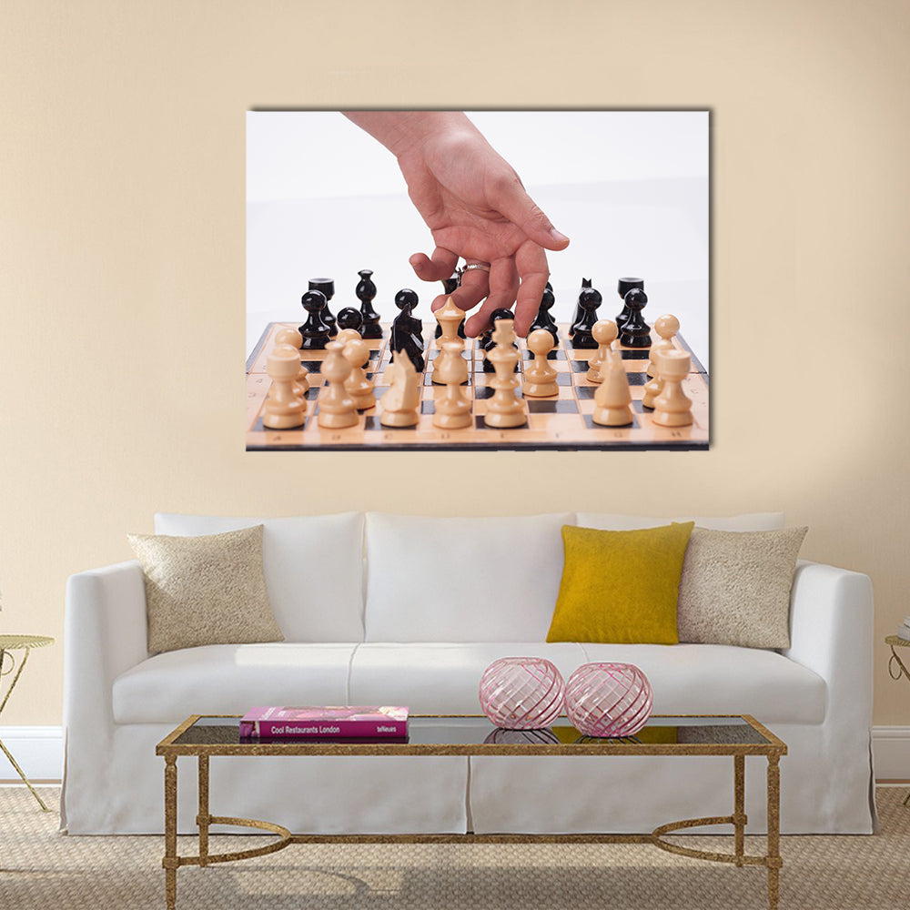 Panning shot of a chess board with a hand moving the chess pieces multi panel canvas wall art