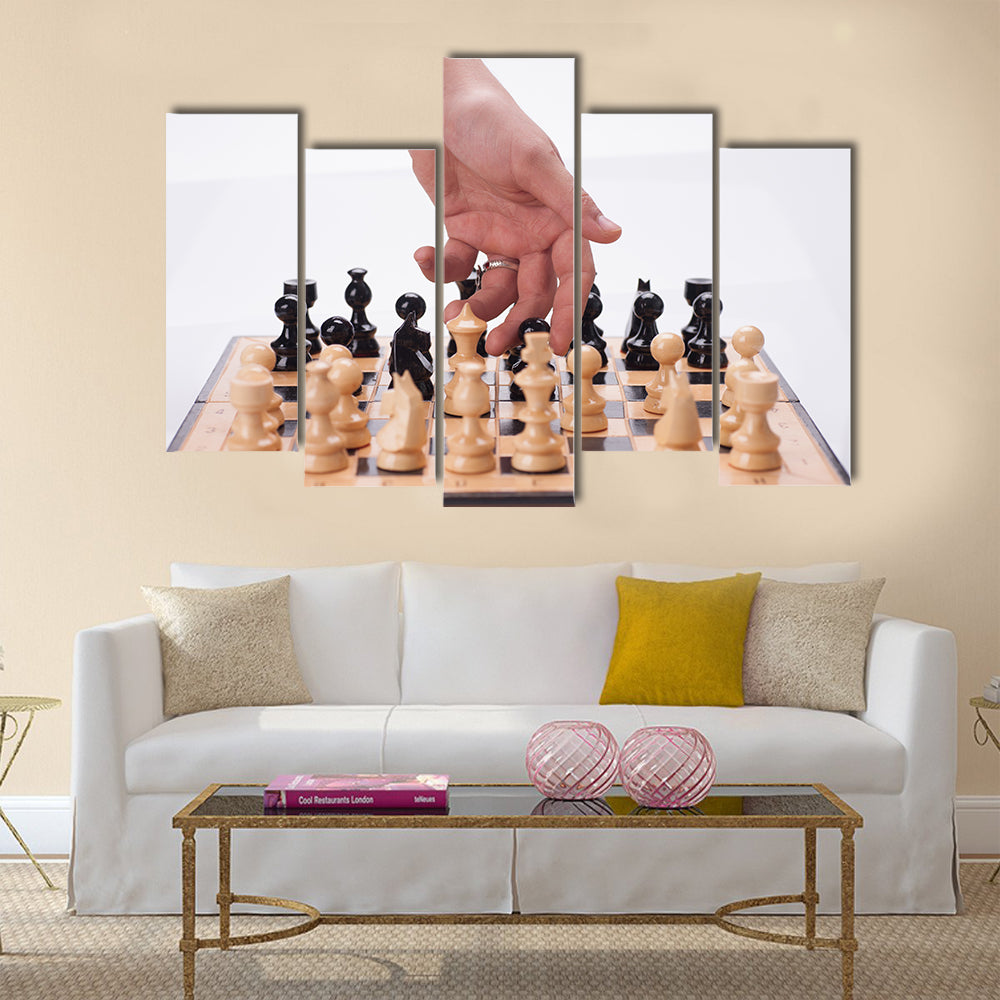 Panning shot of a chess board with a hand moving the chess pieces multi panel canvas wall art