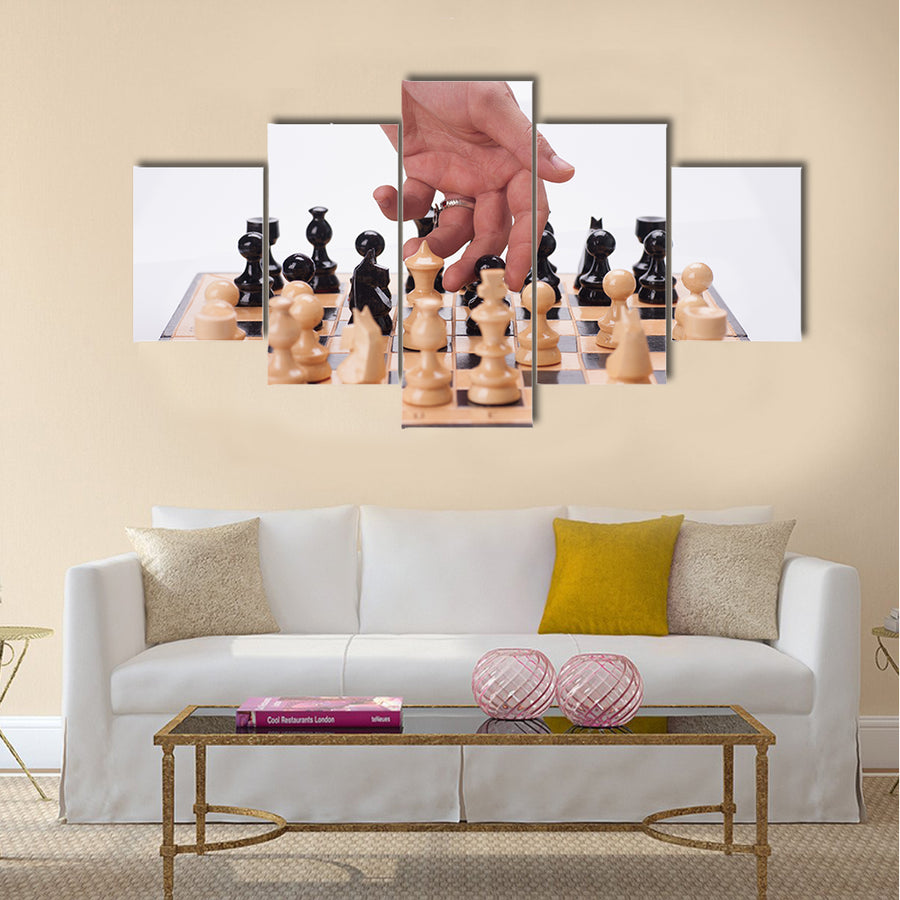 Panning shot of a chess board with a hand moving the chess pieces multi panel canvas wall art