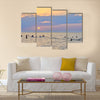 People enjoying themselves and swimming in the sea during sunset multi panel canvas wall art